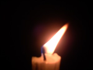 white-burning-candle-and-flame-turned-by-air